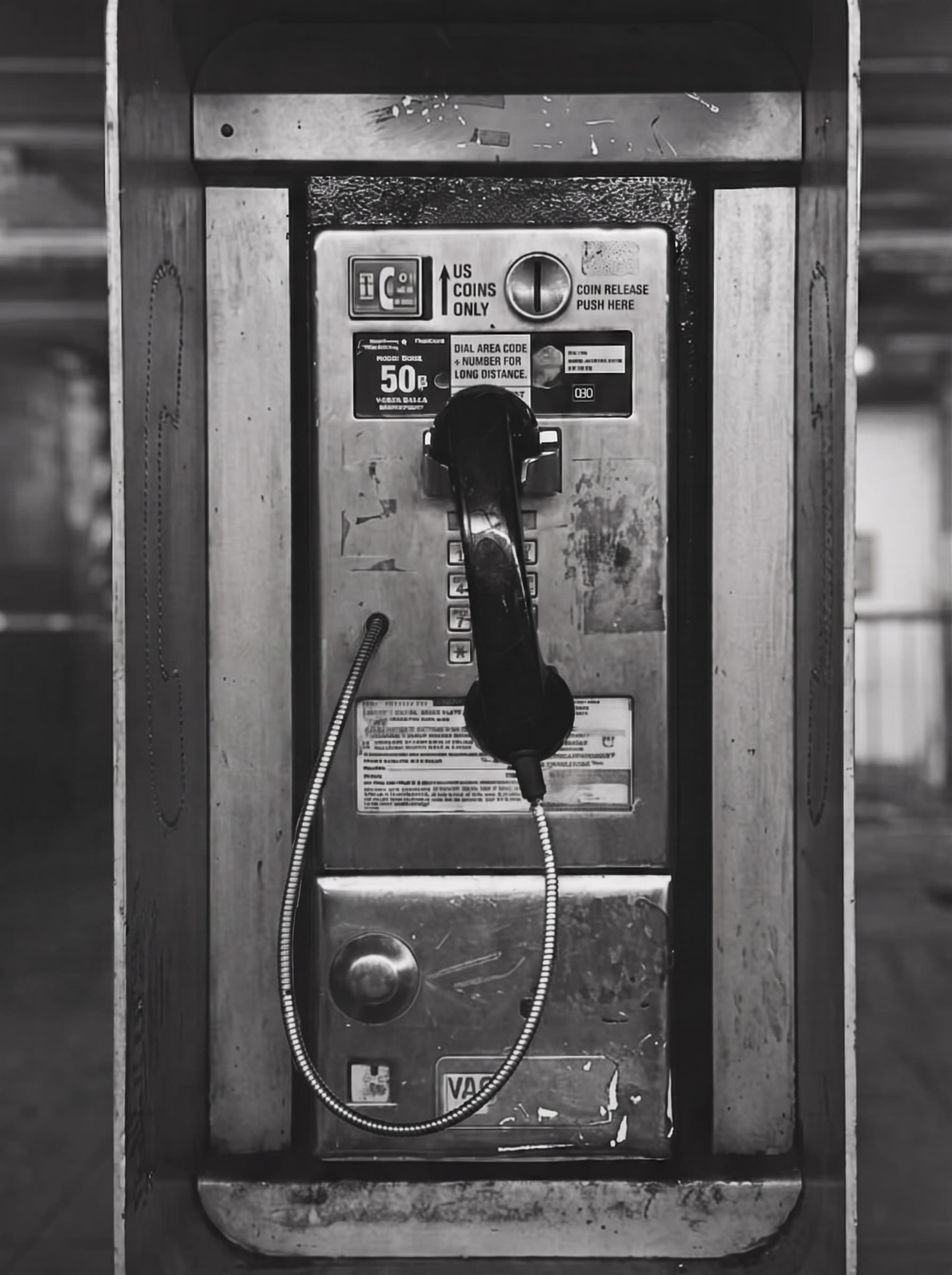 The payphone, an arm's length away. The handset rests on its hook.