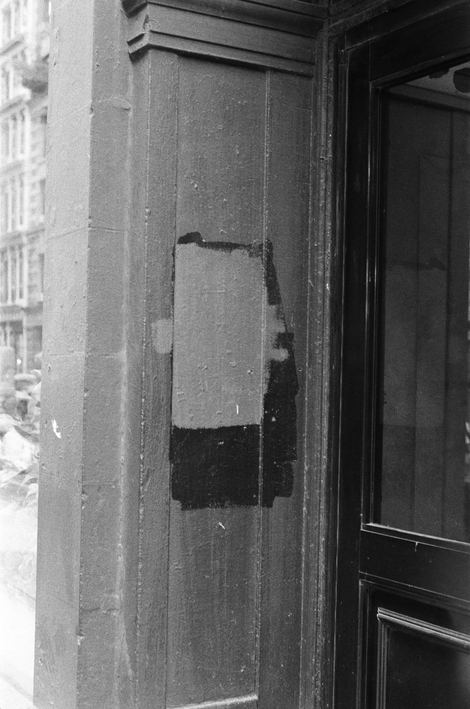 Black-and-white field photograph returned as Frame 10, a doorway before entering.