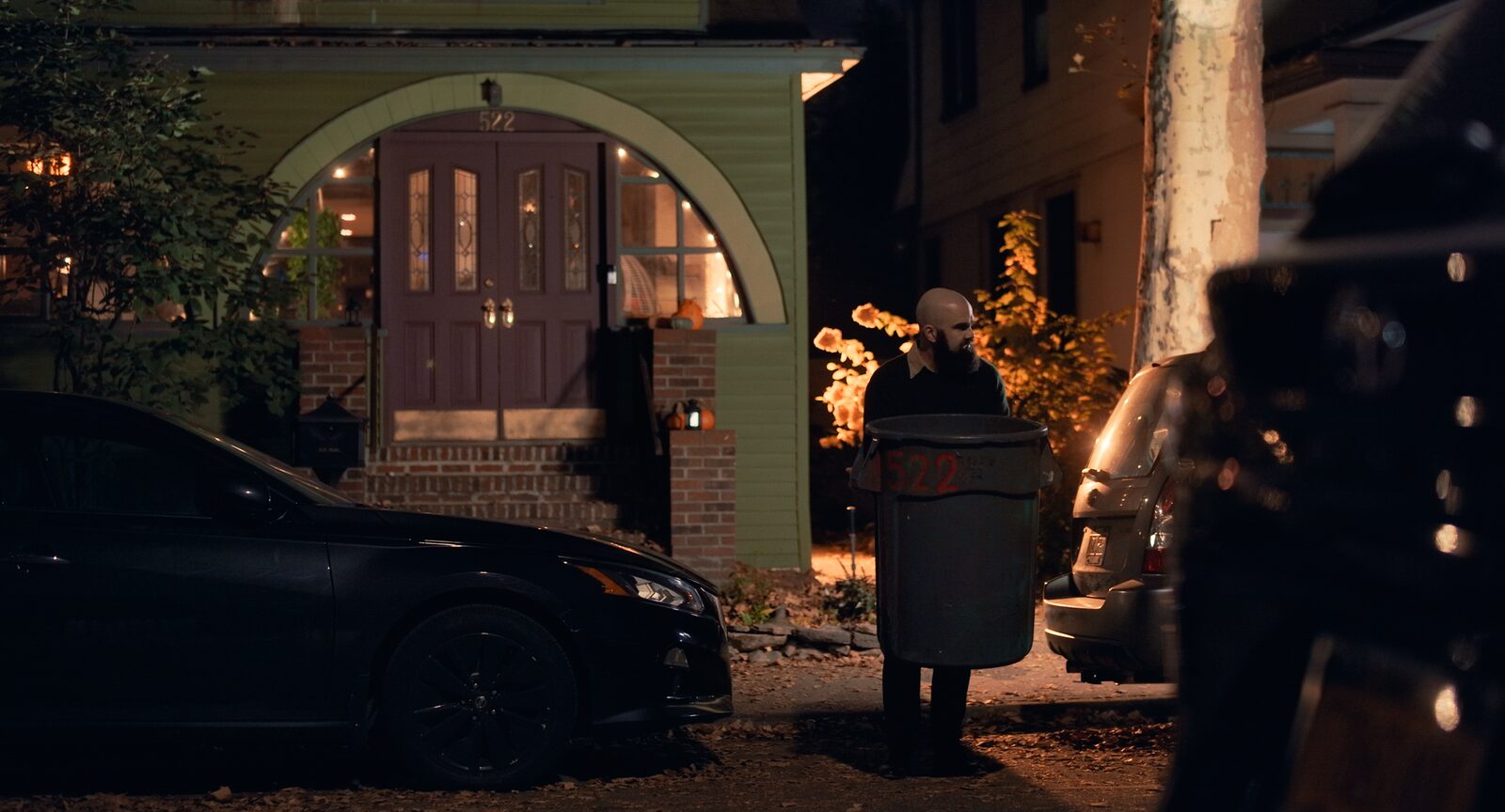 Trash Day — film still, figure waiting with a can